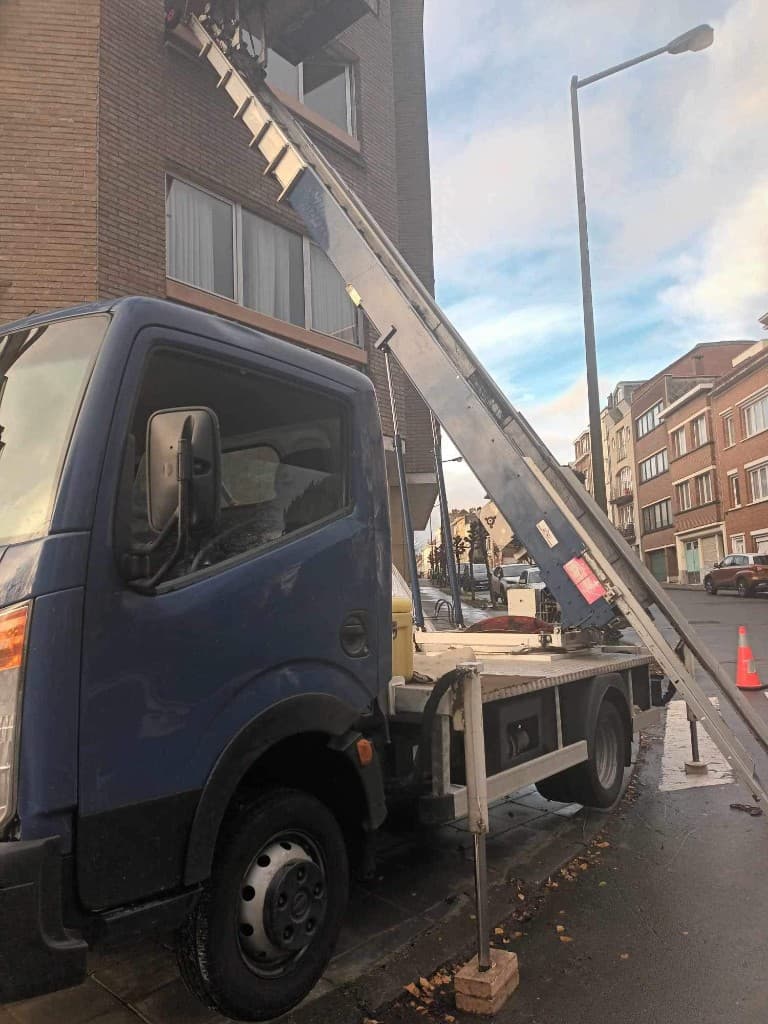 Camion lift avec échelle télescopique le long d'un immeuble résidentiel bruxellois