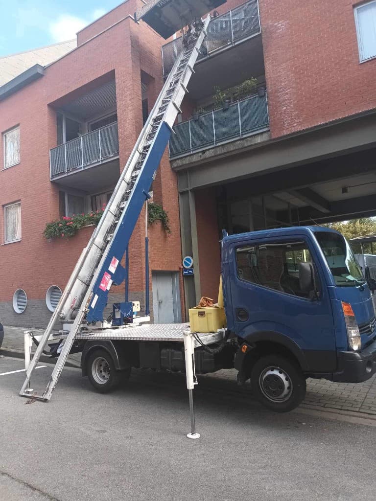 Monte-meuble déployé vers un balcon — immeuble en briques rouges