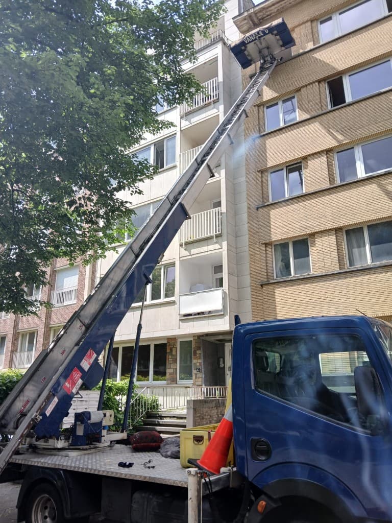 Lift télescopique atteignant un étage élevé d'un immeuble résidentiel